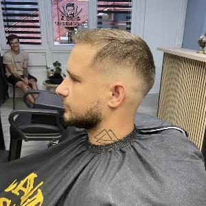 Muškarac sa ručnikom oko vrata nakon šišanja u barber shopu u Novom Zagrebu