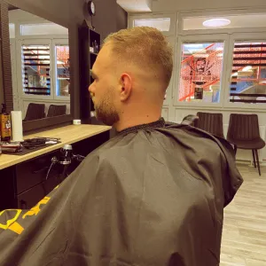 Muškarac srednje dobi sa fade frizurom i toniranom bradom u The Royal Barber Shopu