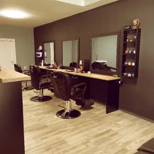 Stolice, ogledala i police sa materijalom i alatima za muško šišanje