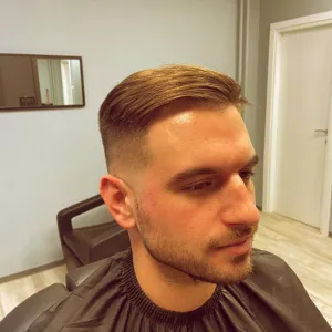 Mlađi muškarac uslikan iz profila sa mid-fade frizurom